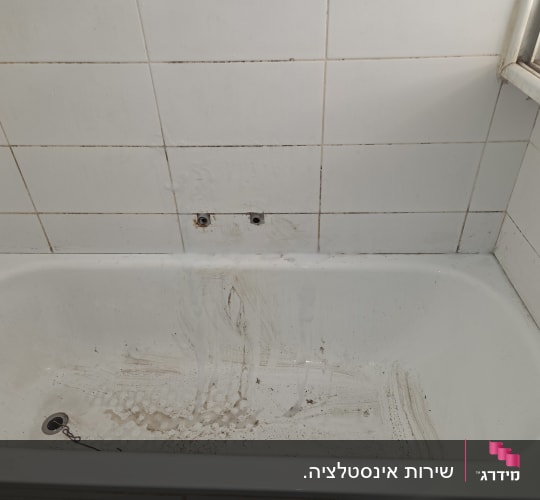 אמבטיה מלוכלכת עם אריחים לבנים